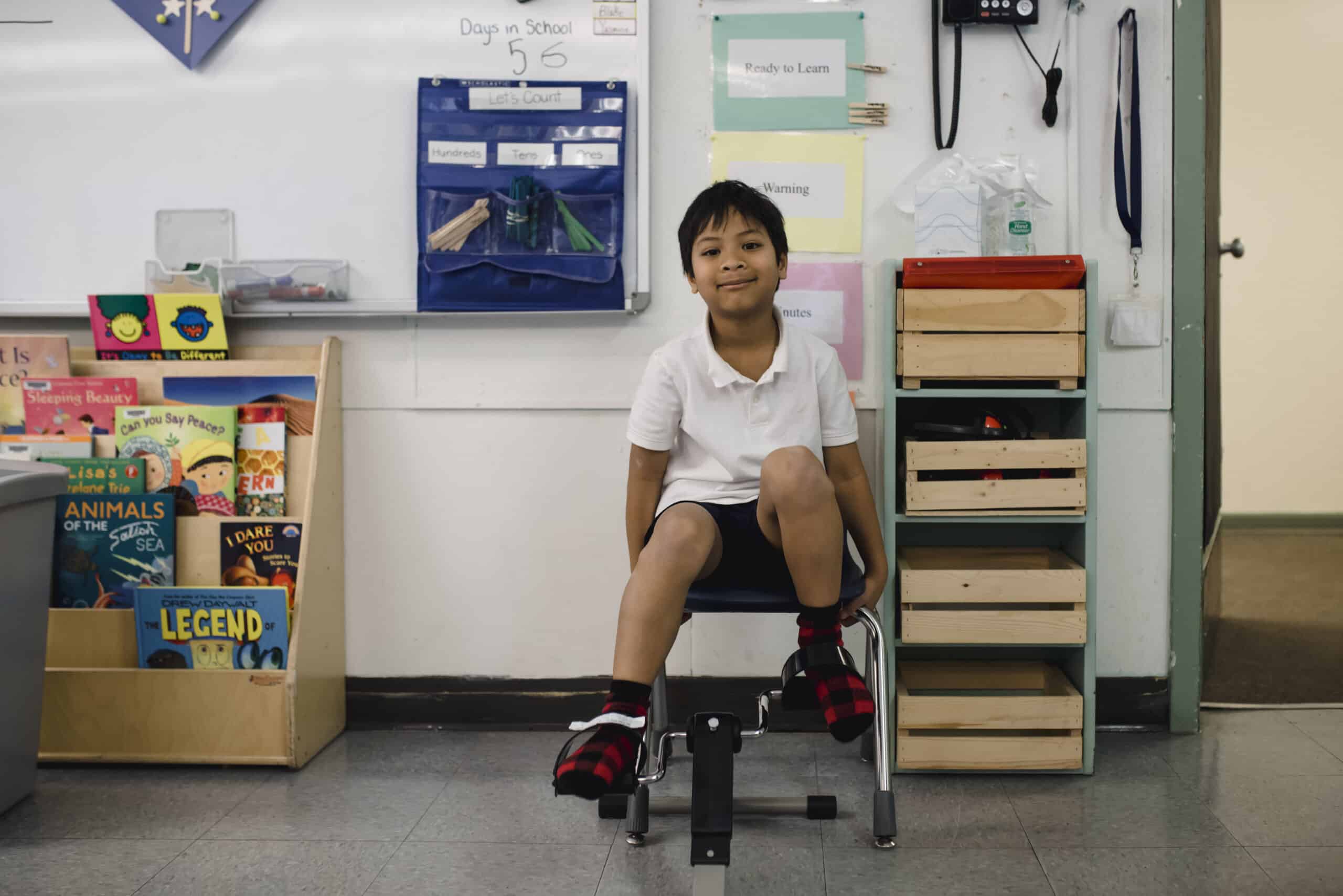 a neurodiverse boy sitting on a chair in an inclusive classroom